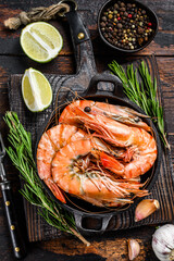 Red Tiger shrimps Prawns in a pan.  Dark wooden background. Top view