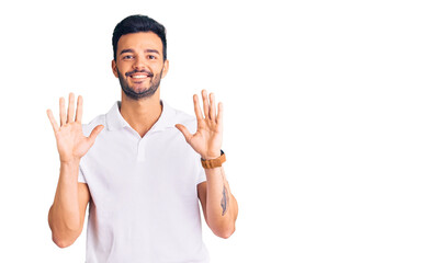Naklejka premium Young handsome hispanic man wearing casual clothes showing and pointing up with fingers number ten while smiling confident and happy.