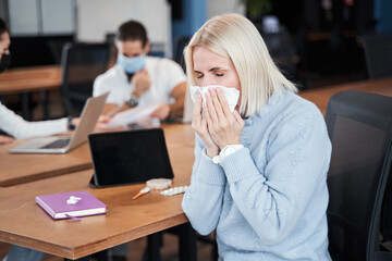 Woman sneezing in paper wipe