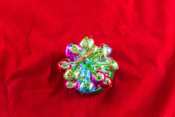 Mini Christmas Tree made of glass illuminated and set against a red background- top view.