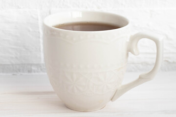 a Cup of black tea in white on a white background