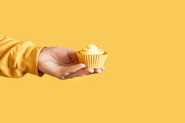 Yellow monochrome bakery. Sustainable cupcake cup. Hold in hand. Gold maffin cream. Trendy...