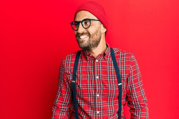 Handsome man with beard wearing hipster elegant look looking to side, relax profile pose with natural face and confident smile.