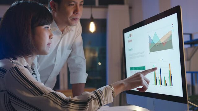Group of Asia businessman and businesswoman using computer presentation and communication meeting brainstorming ideas about new project colleagues working plan success strategy in night home office.