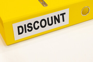 The word discount on a white background with a yellow folder. Business concept