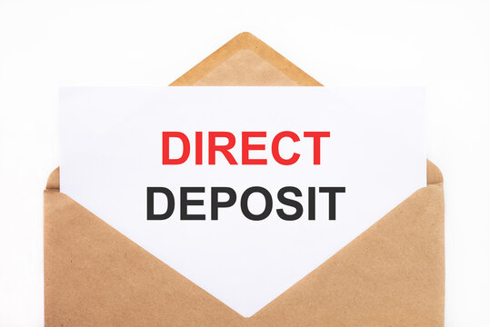A white sheet with the text direct deposit lies in an open craft envelope on a white background with copy space. Business concept image
