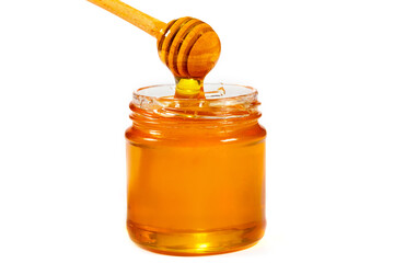 Glass jar of honey with a wooden ladle isolated on white. Organic honey, healthy food, close-up