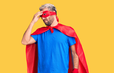 Young blond man wearing super hero custome tired rubbing nose and eyes feeling fatigue and headache. stress and frustration concept.