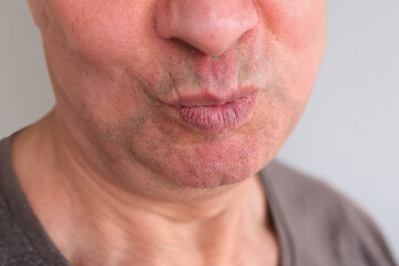funny face of european adult man close up, wrinkles on aging skin, actor's grimaces, human emotions, mental illness