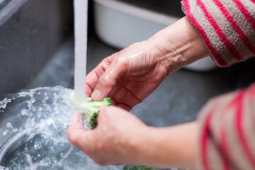 ブロッコリーを水道水で洗う。食事の準備中。クッキング/調理/料理/家事イメージ写真素材