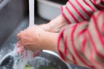 ブロッコリーを水道水で洗う。食事の準備中。クッキング/調理/料理/家事イメージ写真素材