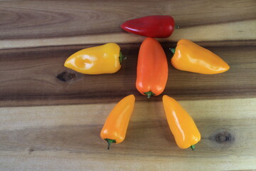 A few different colored peppers on a kitchen board