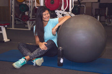 Young, beautiful, sports girl rest on a fitball at the sport gym