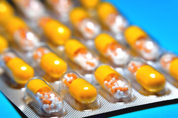 capsules in a blister, a medicine, tablets, vitamins in the form of granules in a yellow capsule,...