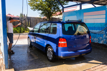 Car wash, rinse with excess water and foam on the car, clean on a wet car.