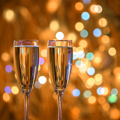 Champagne glass close up on Christmas and New Year holiday bokeh background. Two glasses with bubbly tasty sparkling drink. Happy New Year! Celebrating winter holidays, 4K, close up, macro
