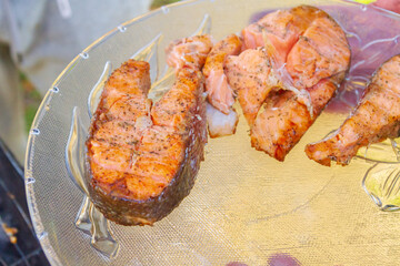 Grilled red fish trout steaks lie on a glass plate