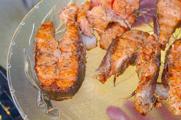 Grilled red fish trout steaks lie on a glass plate
