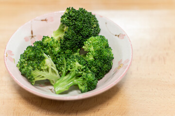 茹でたブロッコリーを器に盛りつける。温野菜。ヘルシーな食事