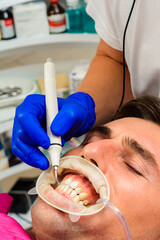Dental practice, the dentist removes stones and hard plaque from the teeth with the help of...