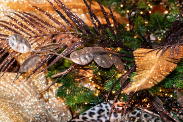 Luxurious Christmas decorations with exotic leaves for a festive interior. Glittering Christmas decorations in a tropical style in trending gold colors.