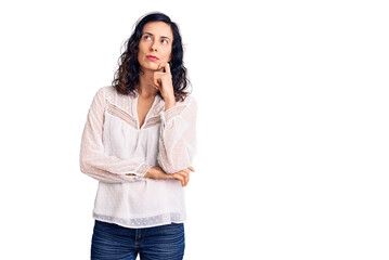 Young beautiful hispanic woman wearing casual clothes serious face thinking about question with hand on chin, thoughtful about confusing idea