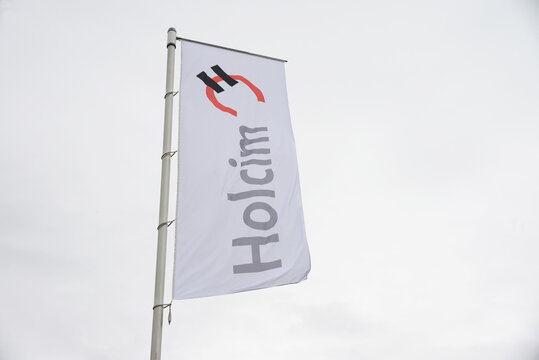 Zeithain, Saxony, Germany - September 27, 2019:  Flag with the logo of Holcim in Zeithain, Germany - Holcim is a Swiss-based global building materials and aggregates company