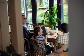 Young family exchanging gifts at dinner. The daughter received a big beautiful box.