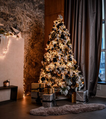 Christmas, New Year interior with loft design home decorated fir tree with garlands, balls and gift present boxes at evening dinner on dark background