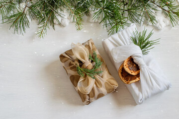 Christmas gift boxes wrapped in textile fabric in traditional japanese furoshiki style. Festive home decor, zero waste, diy concepts.