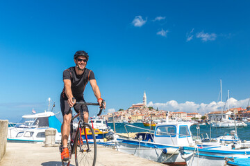 Croatia, Istria, Rovinj, portrait of male cyclist against cityscape