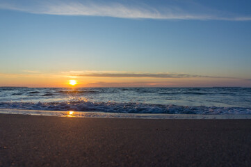 Sunset over the sea. Reflection of sunlight in the sea waves. The sky in the sunset rays. Baltic Sea.