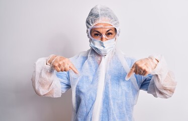 Middle age nurse woman wearing protection coronavirus equipment over white background looking confident with smile on face, pointing oneself with fingers proud and happy.
