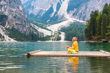 Italien, Südtirol, Pustertal, Pragser Wildsee, Frau macht Yoga auf einem Floss am See