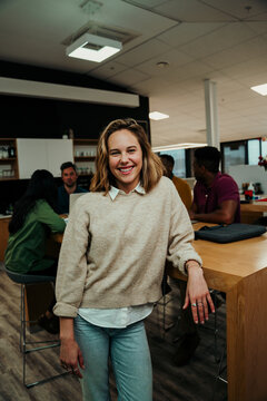 Smiling caucasian woman standing leaning against table enjoying lunch break 