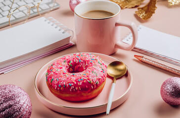 Christmas home office desk with computer keyboard, donut, cup of coffee and christmas decorations.