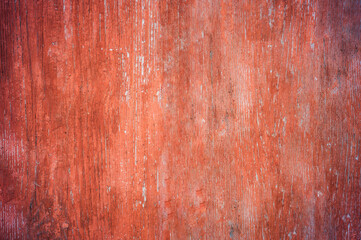 wooden door with old red paint before painting closeup in front, contrast