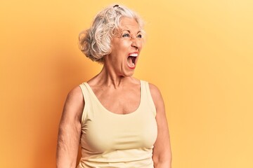 Senior grey-haired woman wearing casual clothes angry and mad screaming frustrated and furious, shouting with anger. rage and aggressive concept.