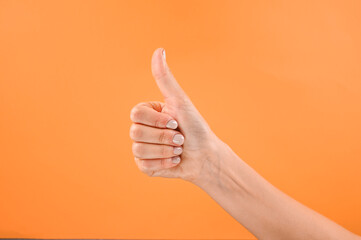 Thumb up on orange background