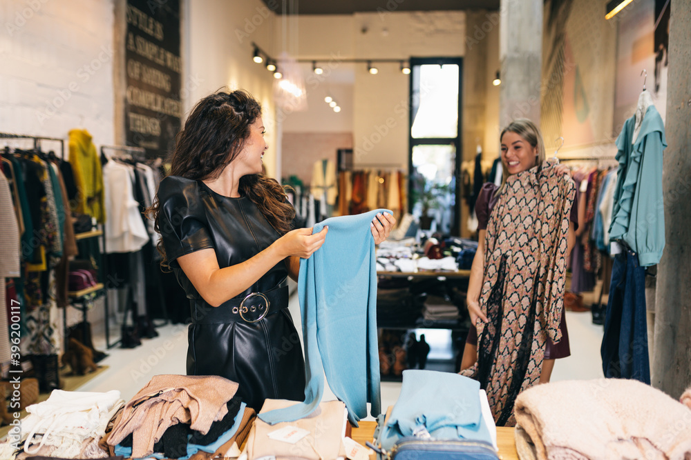 Canvas Prints beautiful young women trying elegant clothes in expensive boutique or store.