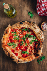Pizza Margherita on a wooden background. Freshly baked crispy pizza with tomatoes and mozzarella.