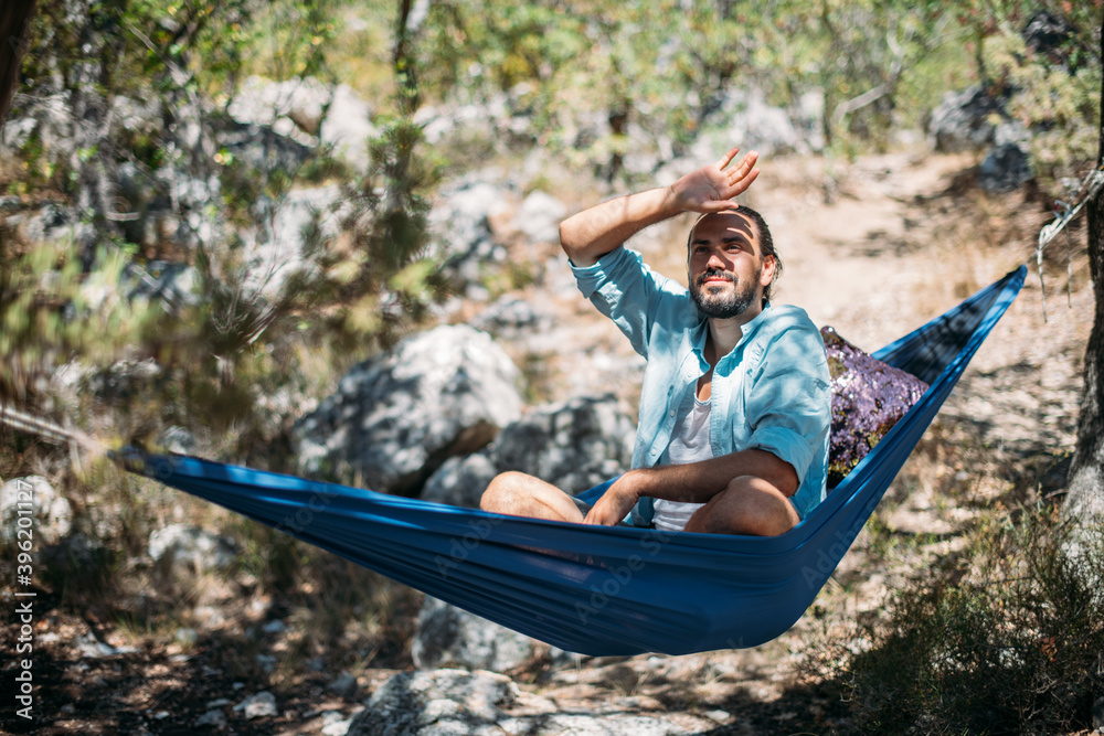 Wall mural A man in a hammock on a hike in the mountains.