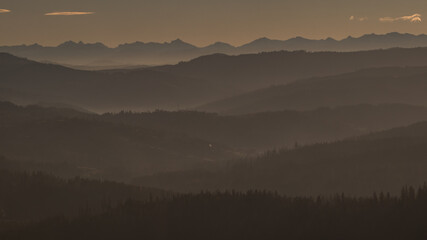 Beautiful sunrise at Ochodzita mountain with a view towards the Beskidy mountains early in cold winter months.