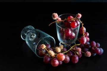 Red grapes, large bunch of fruits, fresh and tasty simple food with bright colors on a black background. flowers and fruit for an artistic food composition