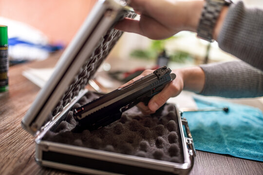 Man putting gun in safe box