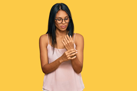 Young african american woman wearing casual clothes and glasses suffering pain on hands and fingers, arthritis inflammation