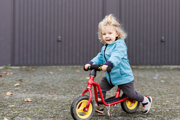 enfant fille roulant en draisienne