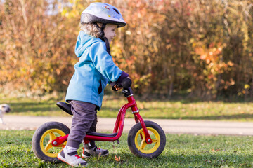 petite fille en draisienne en automne