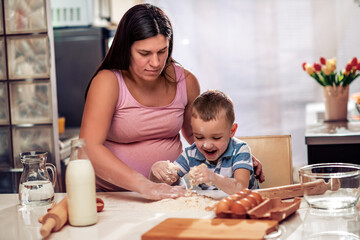 Pregnant woman and son making cookies.