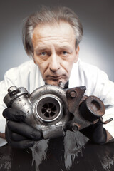 Man checking and measuring carbonized turbocharger on table